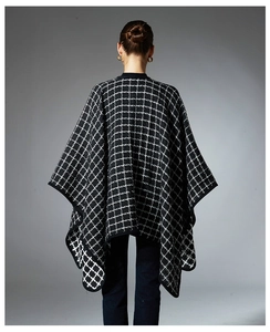 Back view of woman wearing a black and white plaid shawl with elegant knit texture