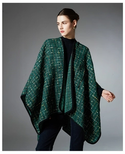 Detailed close-up of dark green tweed shawl featuring woven texture and black hem finish