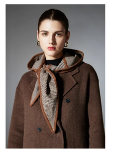 Détail d'une écharpe à capuche écossaise d'hiver avec un manteau en laine marron à boutonnage