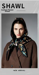 Detail of paisley print hooded shawl with orange and teal patterns on black base