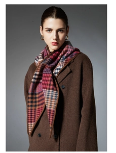 Detail of a 100% wool scarf featuring a vibrant multicolored plaid and houndstooth pattern