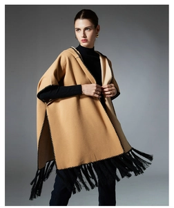 Detail of camel hooded poncho showing black zigzag embroidery and long tassel fringes