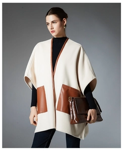 Detail of cream cape shawl with brown leather trimmed pockets and modern wool design