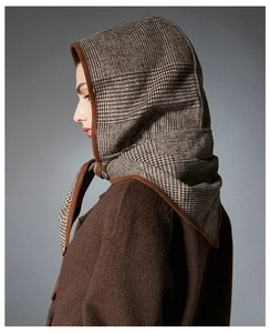 Détail de l'écharpe à capuche à carreaux vintage avec bordure brune et texture épaisse