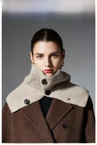 Close-up of beige ribbed knit wool neck gaiter with black buttons on a wool coat
