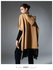 Detail of camel hooded poncho shawl featuring black wavy embroidery and long fringe hem
