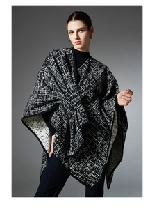 Detail of premium black and white plaid faux mink knitted shawl with thick texture trim