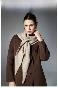 Detail of light camel knit scarf with soft wool texture styled on a dark wool coat