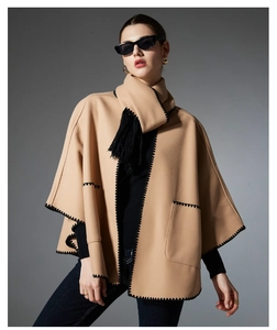 Detail of camel wool poncho with black whipstitch edges and thick fringe trim