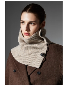 Detail view of beige wool blend neck warmer with large black button decorative closures