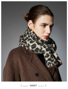 Close-up of leopard print scarf texture with hand-stitched edges and brown wool coat