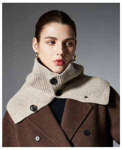 Detail of beige buttoned knit scarf with ribbed texture and stand collar over wool coat