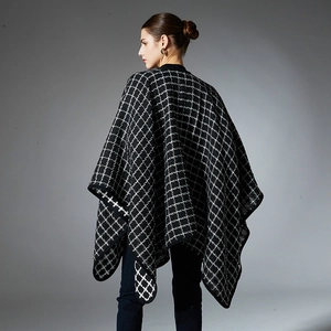 Women's black and white plaid knit poncho wrap shawl shown from a back view silhouette