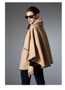 Detail of camel wool shawl with black scallop embroidery and elegant draped silhouette
