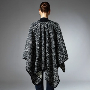Women's black and white checkered knit poncho with a cozy turtleneck for autumn and winter
