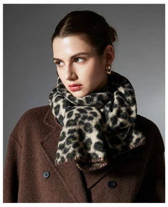 Detailed view of leopard print scarf with brown stitched edges and thick cashmere texture