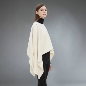 Elegant cream knit cape poncho for women featuring decorative shoulder buttons and asymmetrical hem