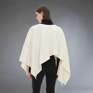 Elegant cream knit poncho for women with asymmetric hem and soft texture back view