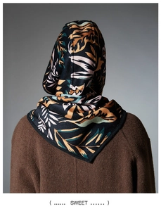 Detail view of tropical leaf pattern hood and triangle scarf over a wool coat