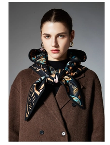 Close-up of a black silk scarf with paisley pattern styled with a brown wool coat