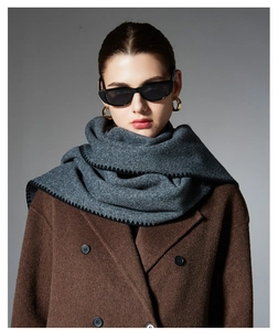 Detail view of dark grey winter scarf featuring distinct black zigzag stitched edges