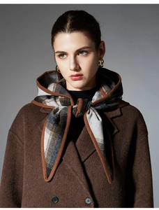Detail of wool blend hooded scarf cape with classic grey and brown plaid pattern