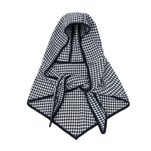 Gros plan sur le poncho en tricot à motif pied-de-poule avec capuche et finitions soignées