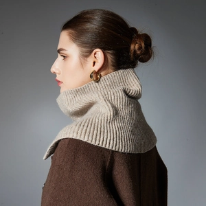 Elegant beige buttoned wool knit neck warmer scarf paired with a brown wool coat