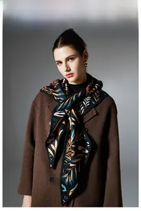 Detail of triangle scarf with paisley leaf pattern paired with a brown wool coat