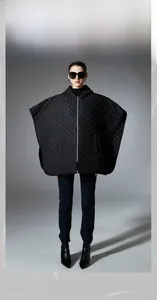Close-up of black quilted hooded shawl featuring classic diamond stitch and front zipper