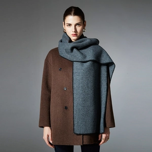 Gray double-sided knit scarf paired with a dark brown wool coat for winter minimalist style