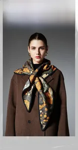 Detailed close-up of double-sided triangular shawl with floral leaf patterns on wool coat