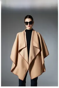 Detailed view of camel cashmere-feel poncho with dark brown contrast leather-like piping