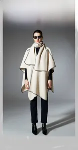 Detail of off-white shawl with black contrast stitching worn by fashion model