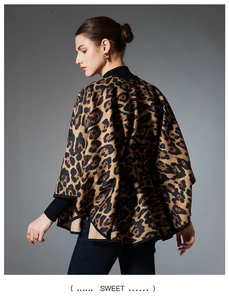 Close-up detail of leopard print knit poncho with black trim and sleek texture