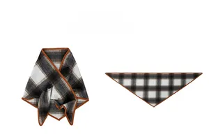 Detail of plaid triangle scarf showing edges and folded texture in brown and grey