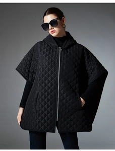 Detail of black quilted hooded poncho featuring a diamond pattern and silver zipper