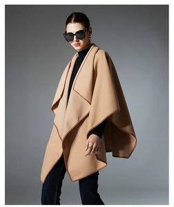 Detail of camel wool poncho shawl featuring elegant contrast dark brown piped edges