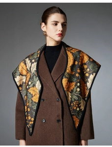 Detailed pattern of floral leaf and berry print scarf paired with a wool coat