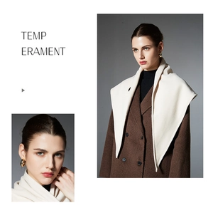 Detail of elegant gold hoop earrings and ring paired with a cream scarf and brown wool coat