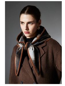 Detail of plaid hooded scarf shawl and brown wool coat showing fabric texture and layers