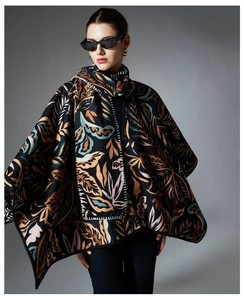 Detail of vintage paisley shawl showing thick knit fabric texture and hand-stitched edging