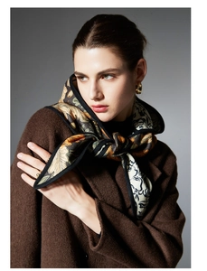 Close-up of a floral pattern scarf paired with a dark brown wool coat and golden earrings