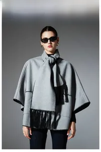 Close-up of gray pocket shawl with black zigzag stitching and long fringe tassels