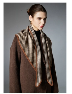 Vue détaillée d'une écharpe triangle marron à motif pied-de-poule avec manteau en laine sombre