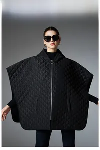 Detailed close-up of quilted diamond pattern and silver zipper on black hooded poncho