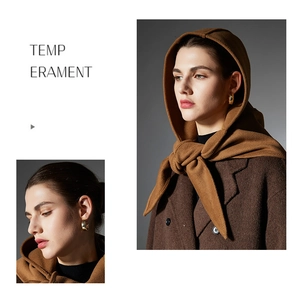 Detail of camel wool balaclava scarf paired with double-breasted coat and gold earrings