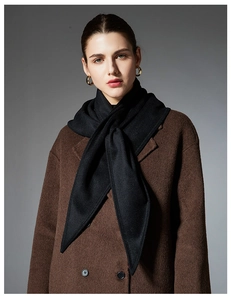 Detail showing high-quality black cashmere winter scarf paired with dark brown wool coat