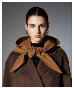 Detail of camel cashmere hooded scarf wrap styled with a dark brown wool coat and gold earrings
