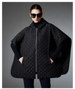 Detailed view of the diamond quilted texture and metal zipper on the black hooded poncho